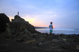 Surfer pro Dede Suryana sedang memandang ombak untuk bersiap surfing di pagi hari